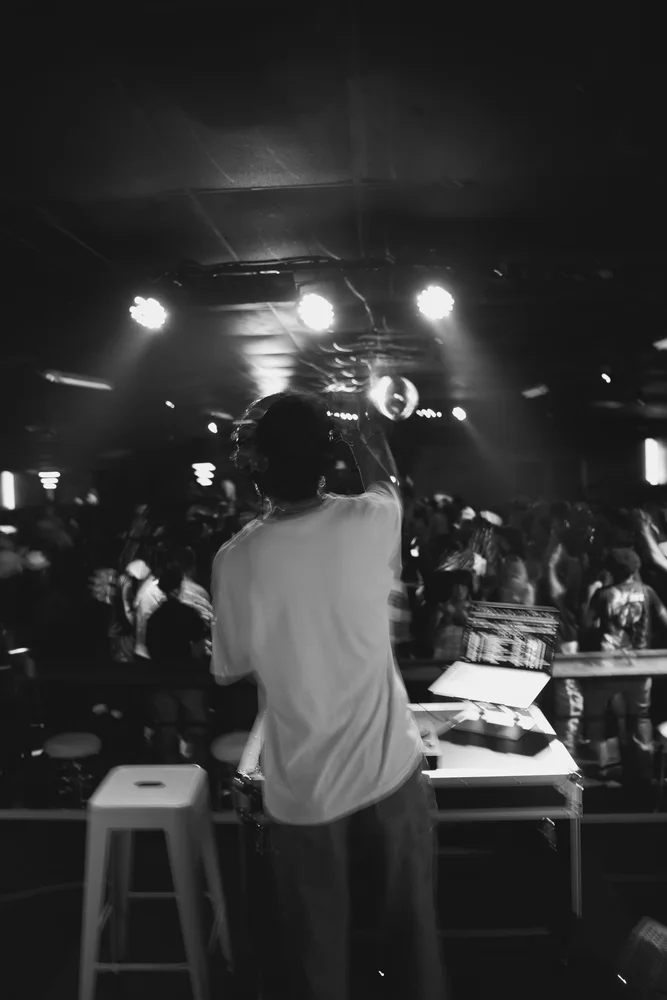 Black and white view from the booth towards the lights over the room