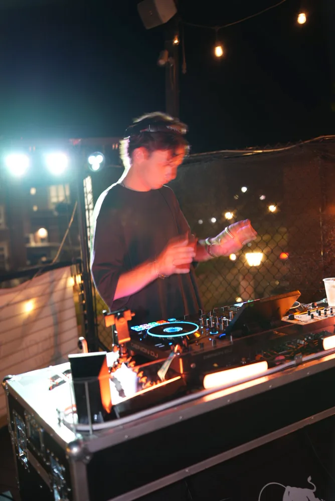 Lane Watt performing under warm rooftop light