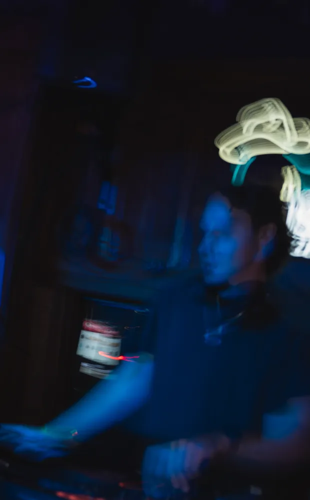 A blue-lit motion portrait of Lane Watt at the booth